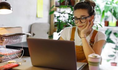 A woman using a laptop at home, representing the FullBeauty Brands class action lawsuit.