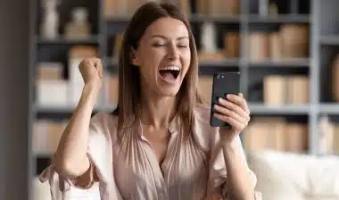 Close up overjoyed woman looking at phone screen about refunded money