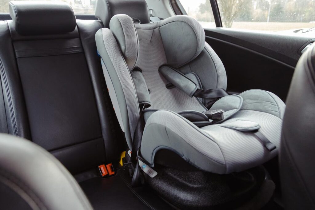 Close up of a baby car seat in the back of a car, representing Nuna class action.