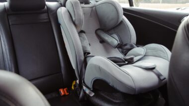 Close up of a baby car seat in the back of a car, representing Nuna class action.