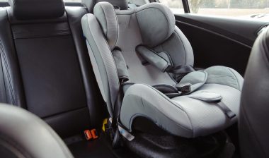 Close up of a baby car seat in the back of a car, representing Nuna class action.