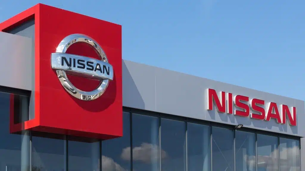 The Nissan logo prominently displayed on the wall of a car dealer's building.