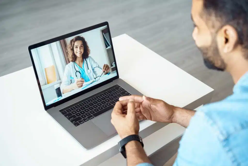 A man chatting with a doctor on a laptop, tele-health concept, representing LifeMD settlement.
