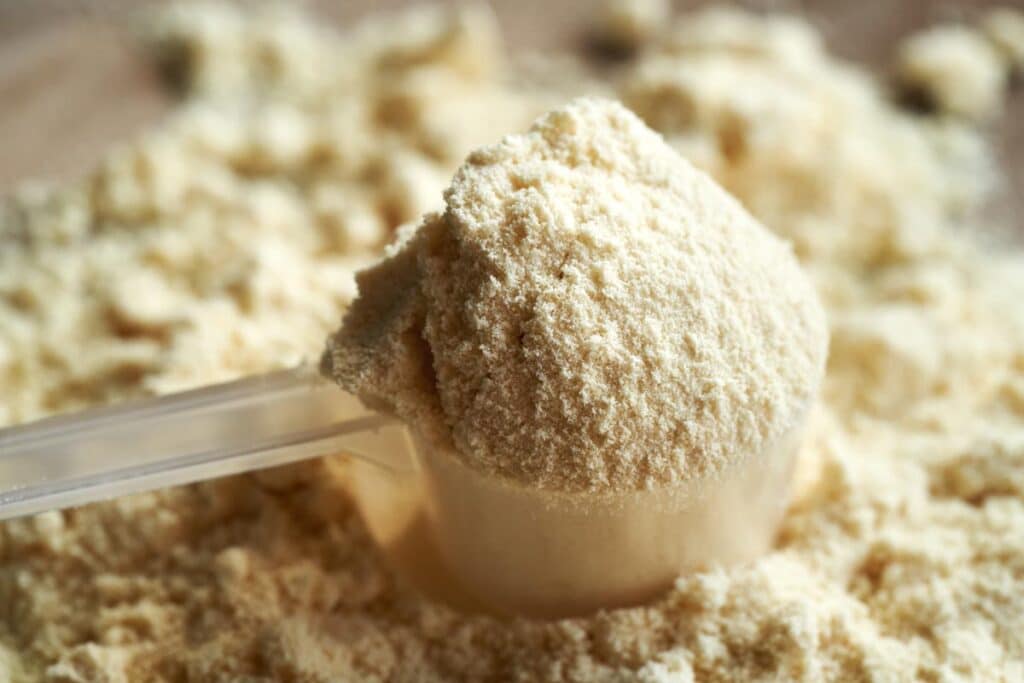 Close up of whey protein in a scoop, representing the Naked Nutrition protein powder class action.