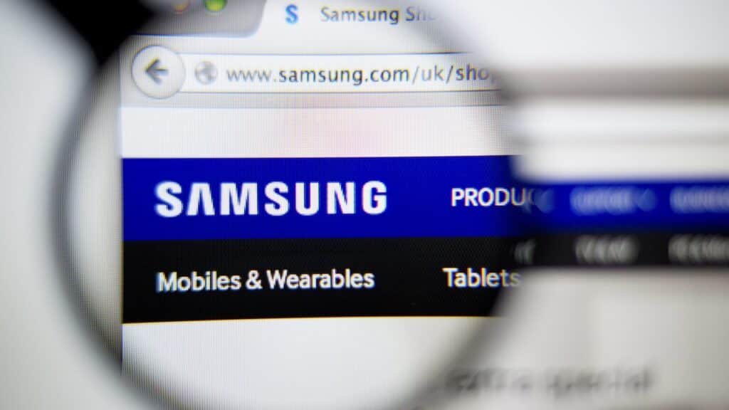 Photo of: www.samsung.com, Samsung homepage on a monitor screen through a magnifying glass.