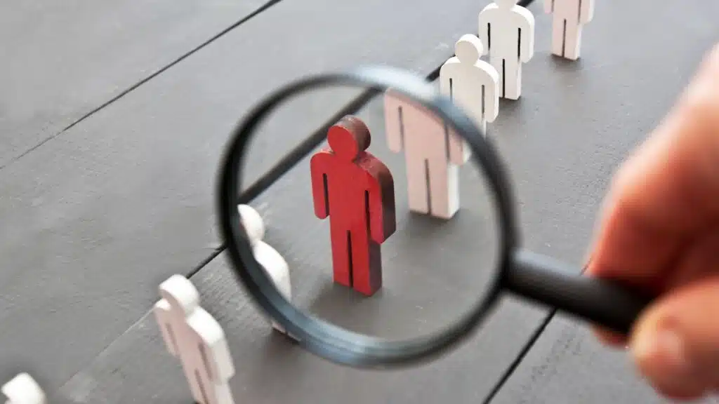 The view through the magnifier on the one wooden red person between other people
