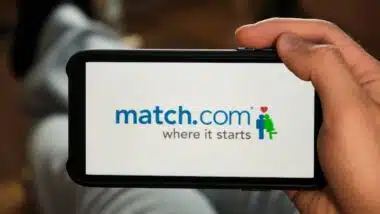 Match com logo on the screen of mobile phone in mans hand.