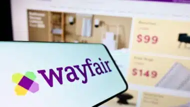 Smartphone with logo of e-commerce company Wayfair Inc. on screen in front of business website.