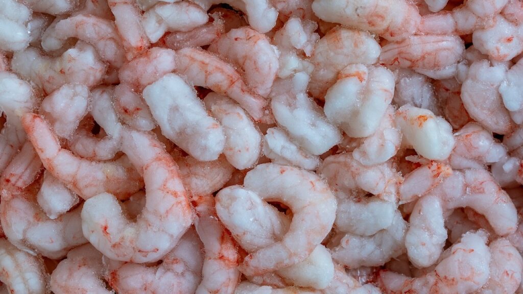 Lots of frozen shrimp for background use, close up, top view.