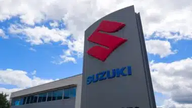 Suzuki motorcycle car dealership logo sign and text brand in shop entrance.