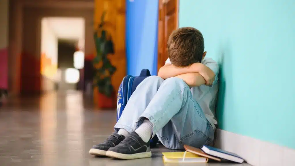 Little boy sitting alone on floor.