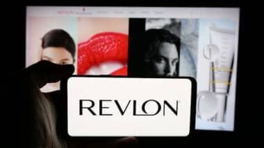 Person holding cellphone with logo of US cosmetics company Revlon Inc.