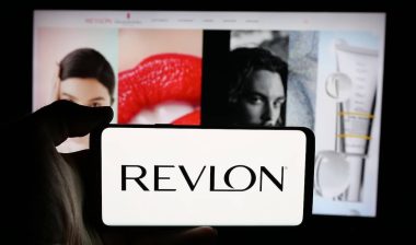 Person holding cellphone with logo of US cosmetics company Revlon Inc.