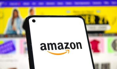 Amazon logo on phone screen with online shopping page background.