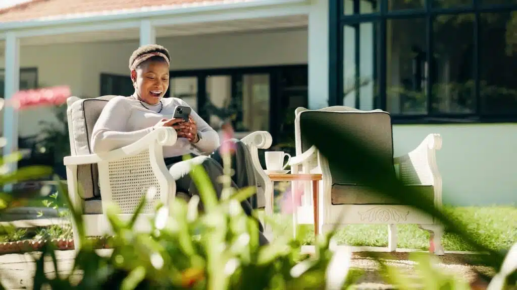 Reading, surprise or black woman with phone in backyard