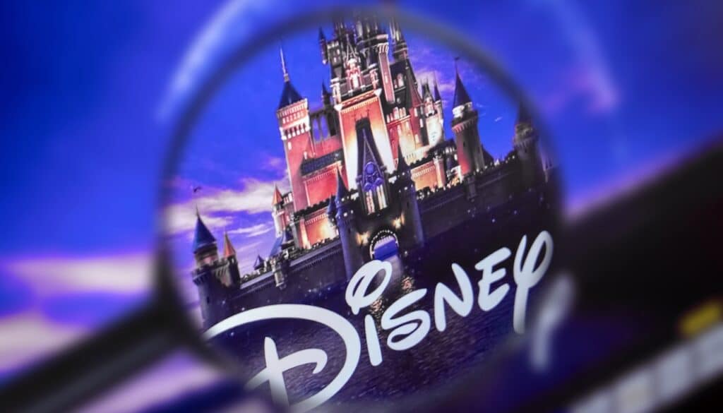 The home page of the Disney site, view through a magnifying glass. Disney company logo is visible. Soft focus.