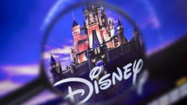 The home page of the Disney site, view through a magnifying glass. Disney company logo is visible. Soft focus.