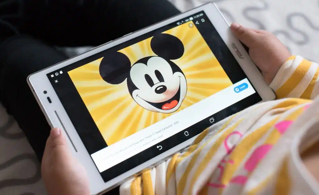 Litlle girl watching mickey mouse educational program