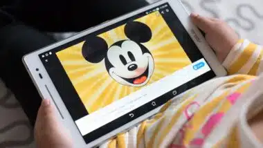 Litlle girl watching mickey mouse educational program