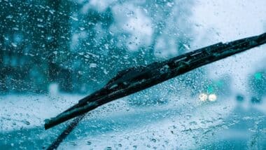 very poor view of the road, through a dirty windshield covered with ice, snow and water