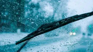 very poor view of the road, through a dirty windshield covered with ice, snow and water