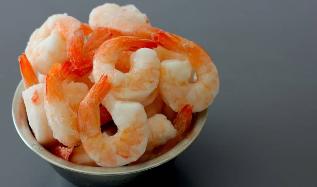Close up on a Bowl Full of Frozen Cooked Shrimp.