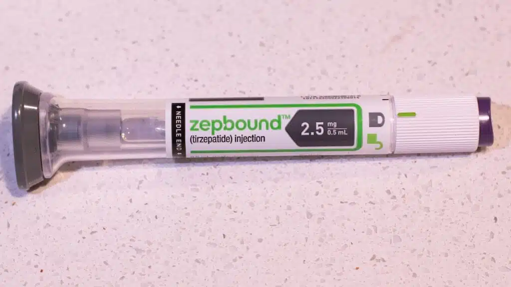 A Zepbound injector pen lays on the bathroom counter.