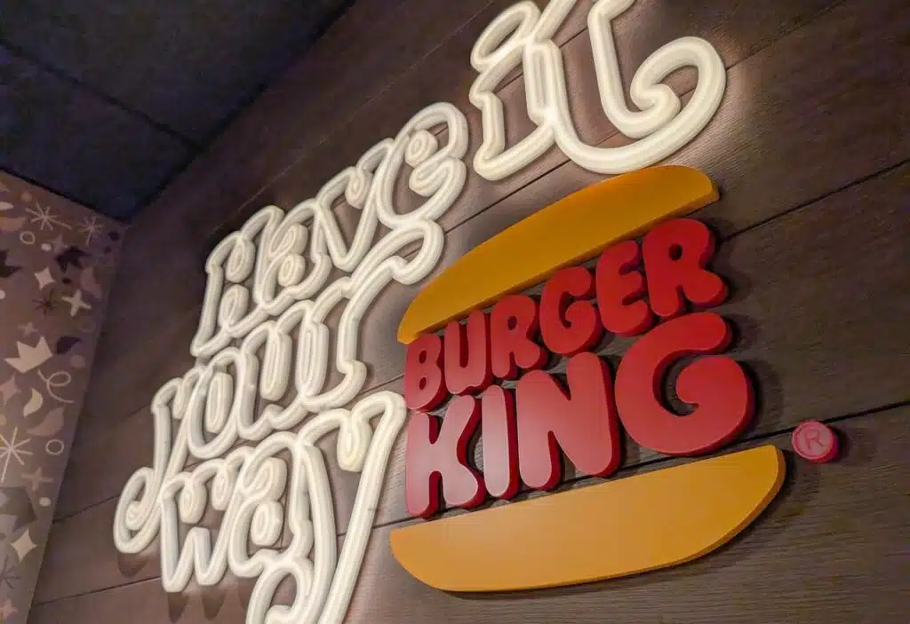 Burger King slogan illuminated on a wooden restaurant wall display