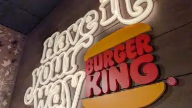 Burger King slogan illuminated on a wooden restaurant wall display