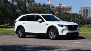 A Mazda CX90 PHEV luxury SUV, cruising near Hermann Park during a great summer day