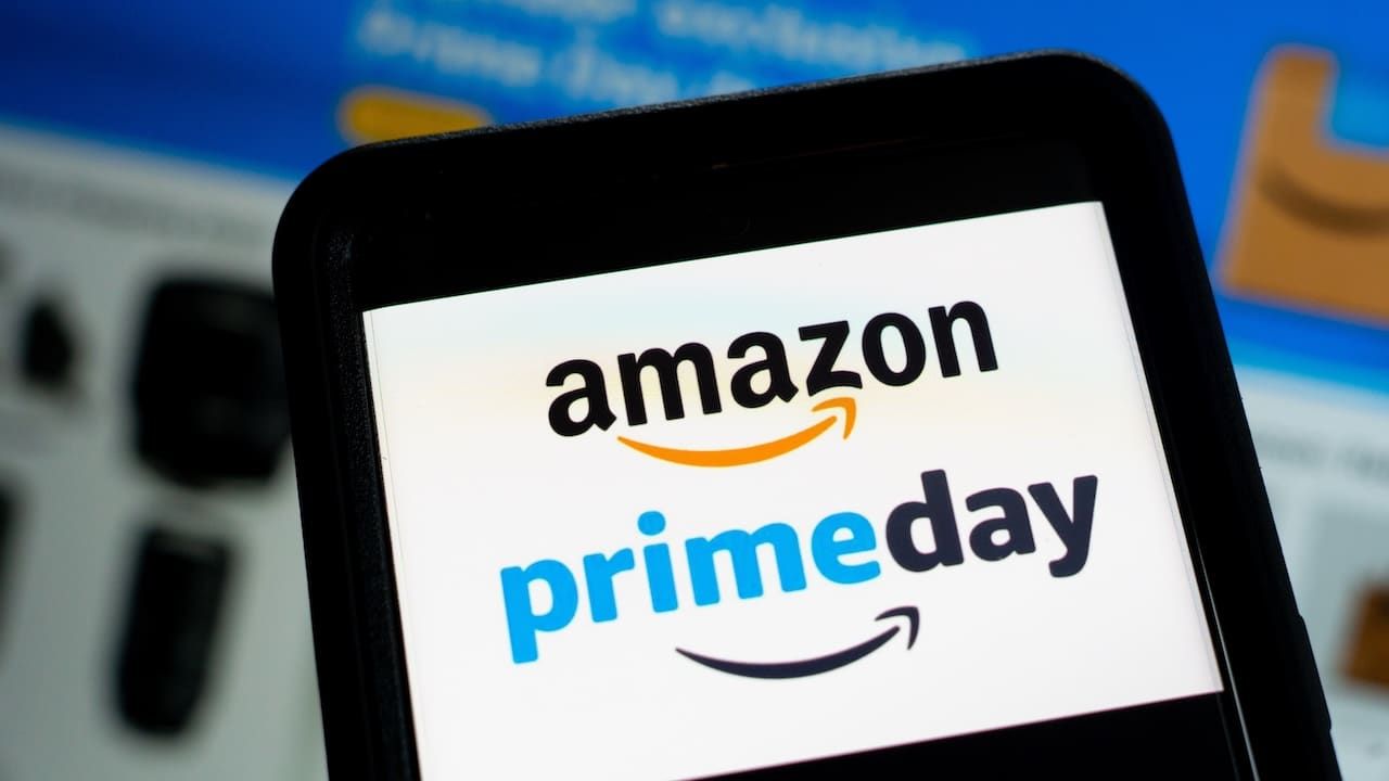 Amazon Prime Day Week Logo On Smartphone And Laptop Screens With Shopping Deals Website In Background