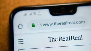 The RealReal web page on the screen of smartphone.
