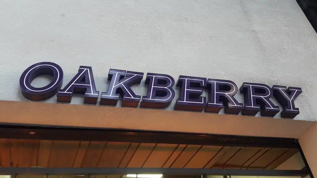 Closeup of the lettering and logo of Oakberry shop, on its facade.