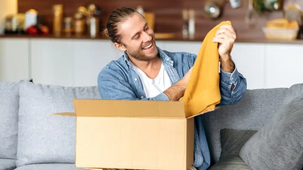A satisfied smiling guy unpacks his long awaited package