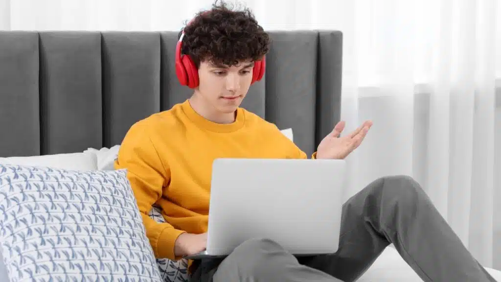 Teenager in headphones chatting with friends on discord.