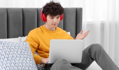 Teenager in headphones chatting with friends on discord.