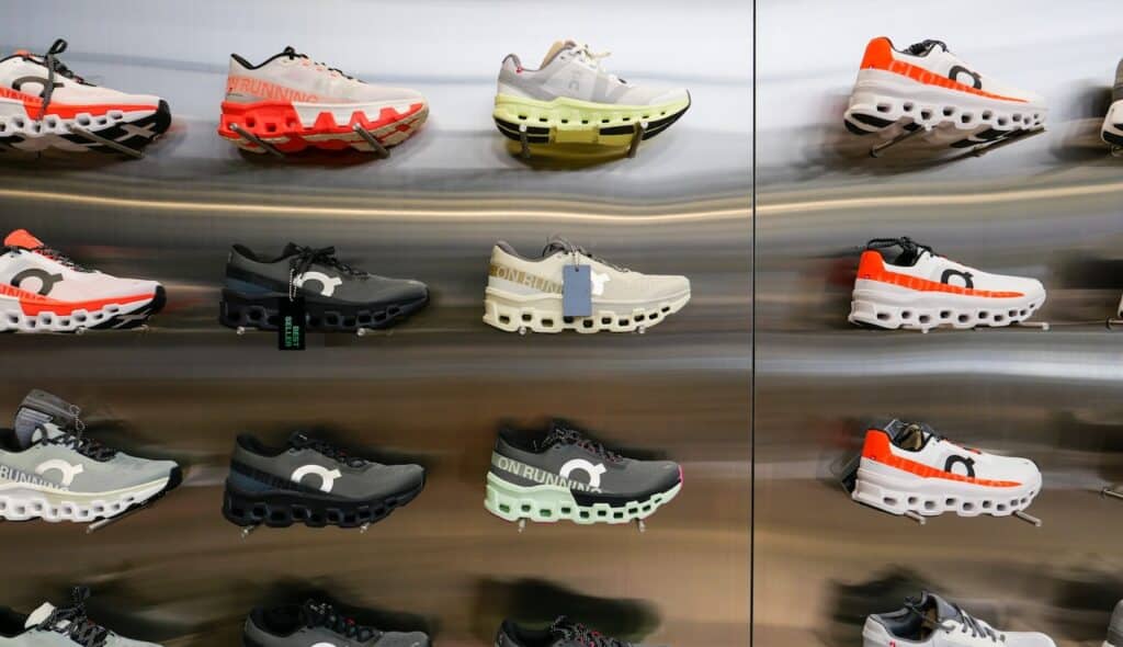 On Cloud Running shoes are against the wall on display at a running shoe specialty store.