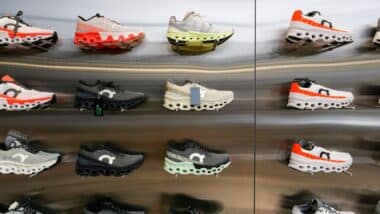 On Cloud Running shoes are against the wall on display at a running shoe specialty store.