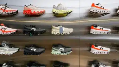 On Cloud Running shoes are against the wall on display at a running shoe specialty store.