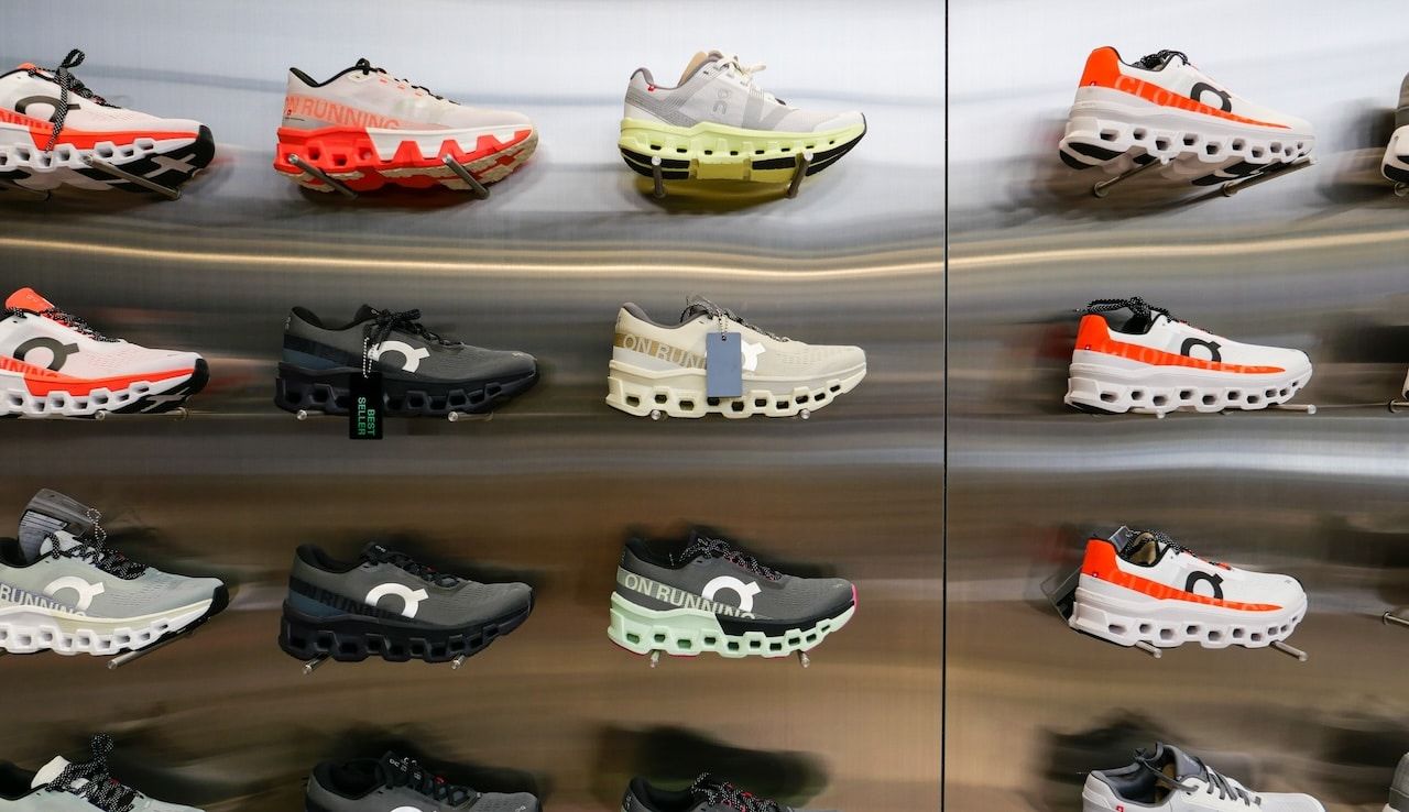 On Cloud Running shoes are against the wall on display at a running shoe specialty store.