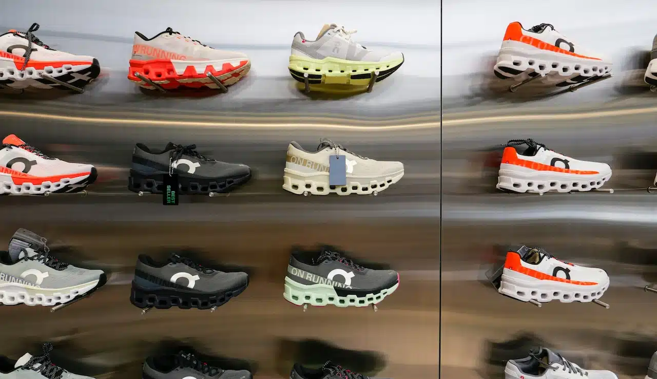 On Cloud Running shoes are against the wall on display at a running shoe specialty store.