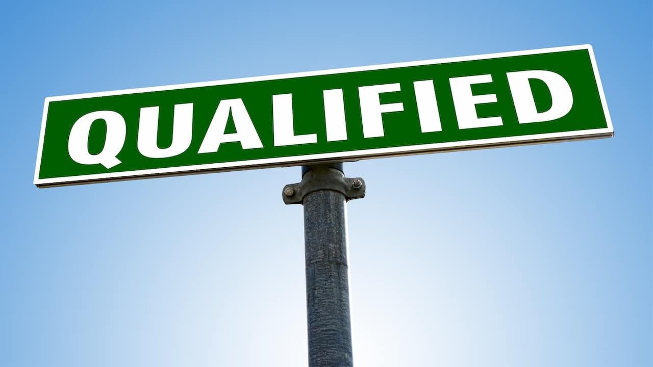 QUALIFIED word on green road sign