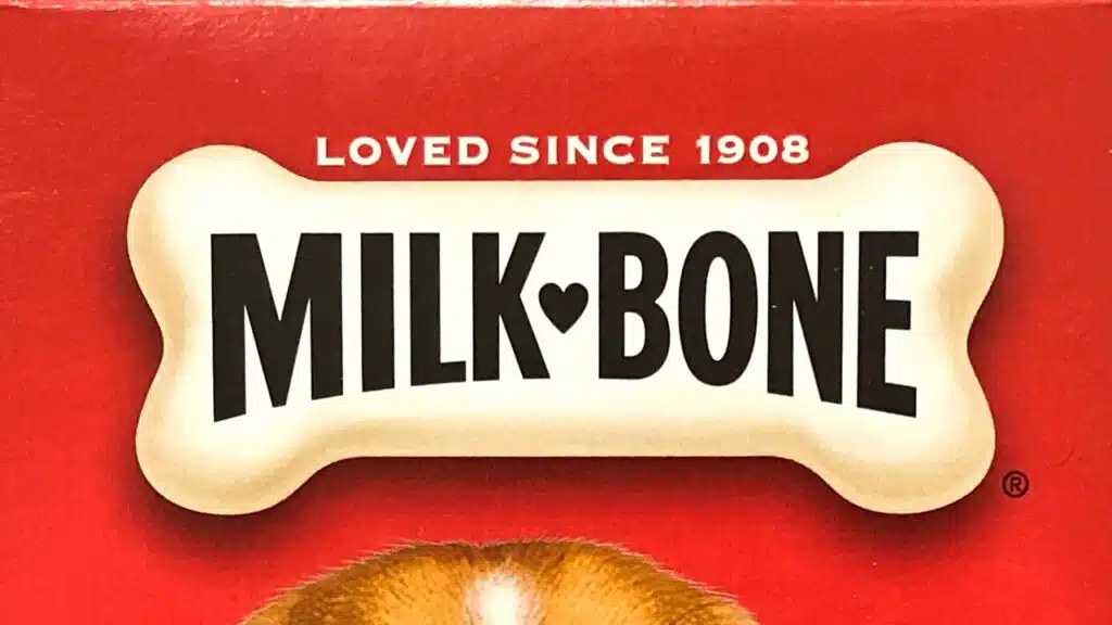 Grocery store shelf with boxes of Milk Bone brand dog treats.