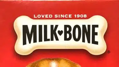 Grocery store shelf with boxes of Milk Bone brand dog treats.