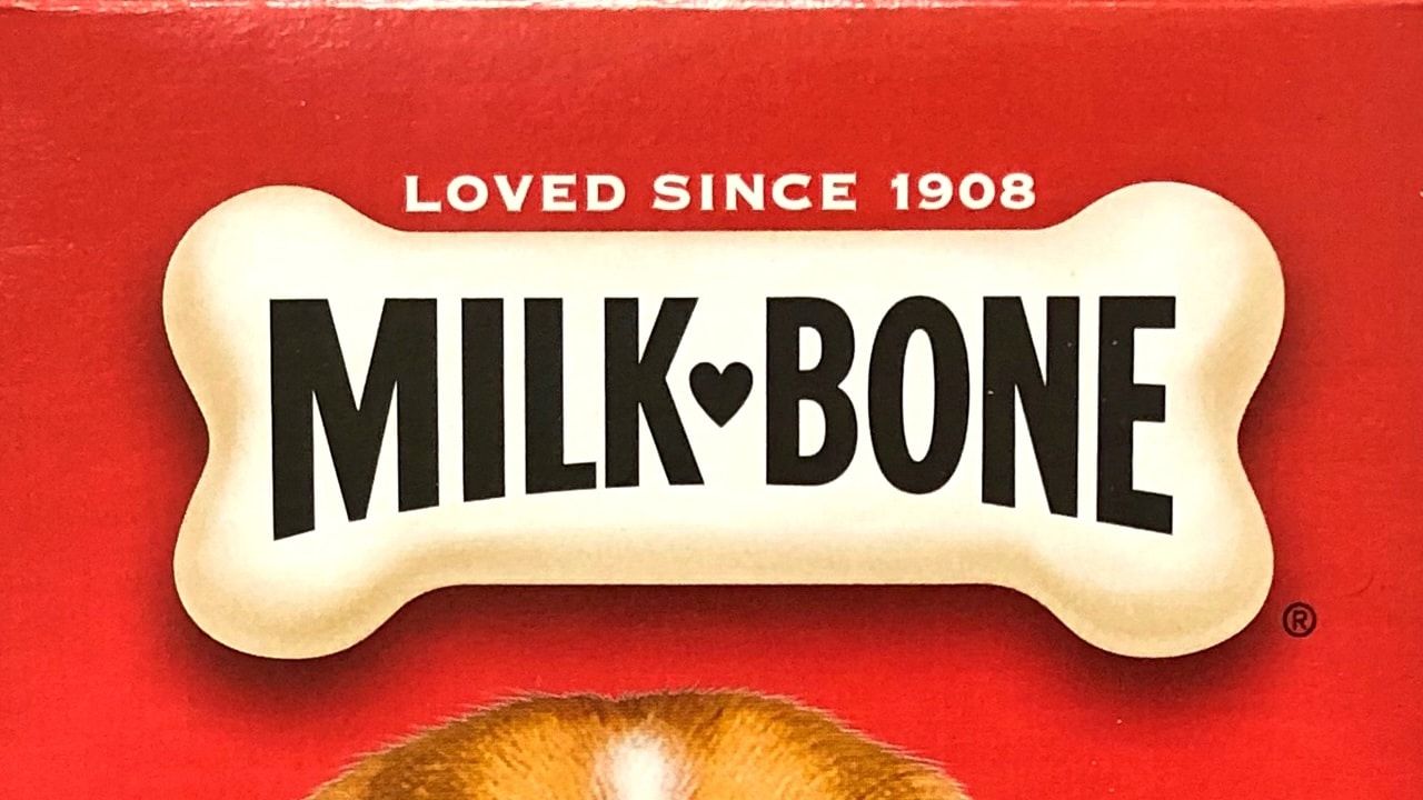 Grocery store shelf with boxes of Milk Bone brand dog treats.