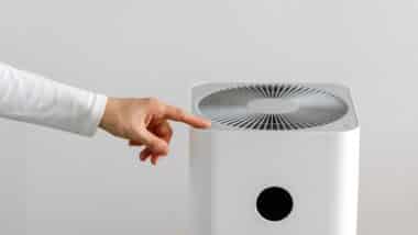 hand turning on air purifier