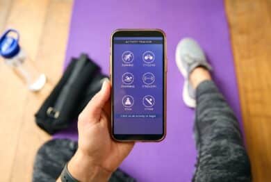 Close Up Of Woman With Smart Watch About To Exercise Looking At Activity Tracker On Mobile Phone