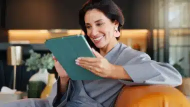 Online booking, smile and tablet with woman in spa for appointment or schedule. Agenda, hospitality and wellness with happy person checking calendar in luxury beauty salon for cosmetic treatment