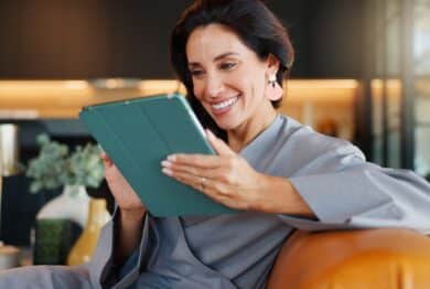 Online booking, smile and tablet with woman in spa for appointment or schedule. Agenda, hospitality and wellness with happy person checking calendar in luxury beauty salon for cosmetic treatment