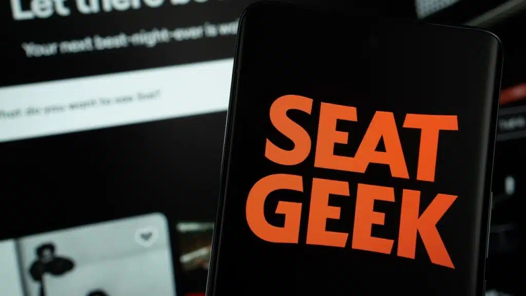 The logo of the SeatGeek is displayed on a smartphone screen, and the website SeatGeek is visible on a computer screen in the background.